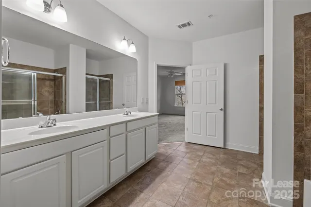 a bathroom with a toilet sink a mirror and shower