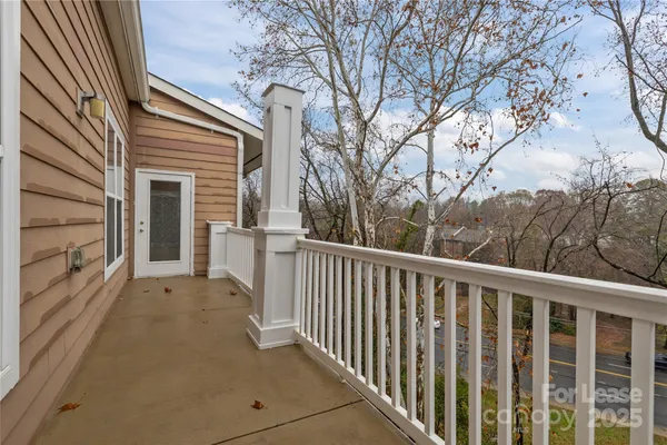 a view of a balcony with wooden floor and fence