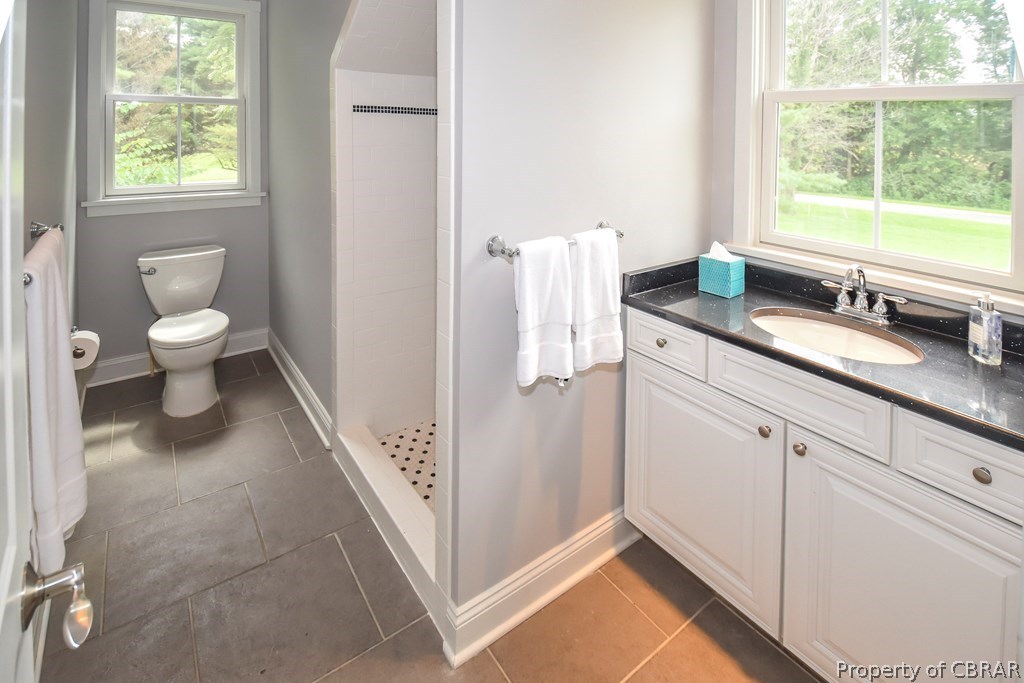 137 Mastons Wharf Road Lancaster, VA 22503 - Photo 33 of 39 a spacious bathroom with a granite countertop sink a toilet and a window