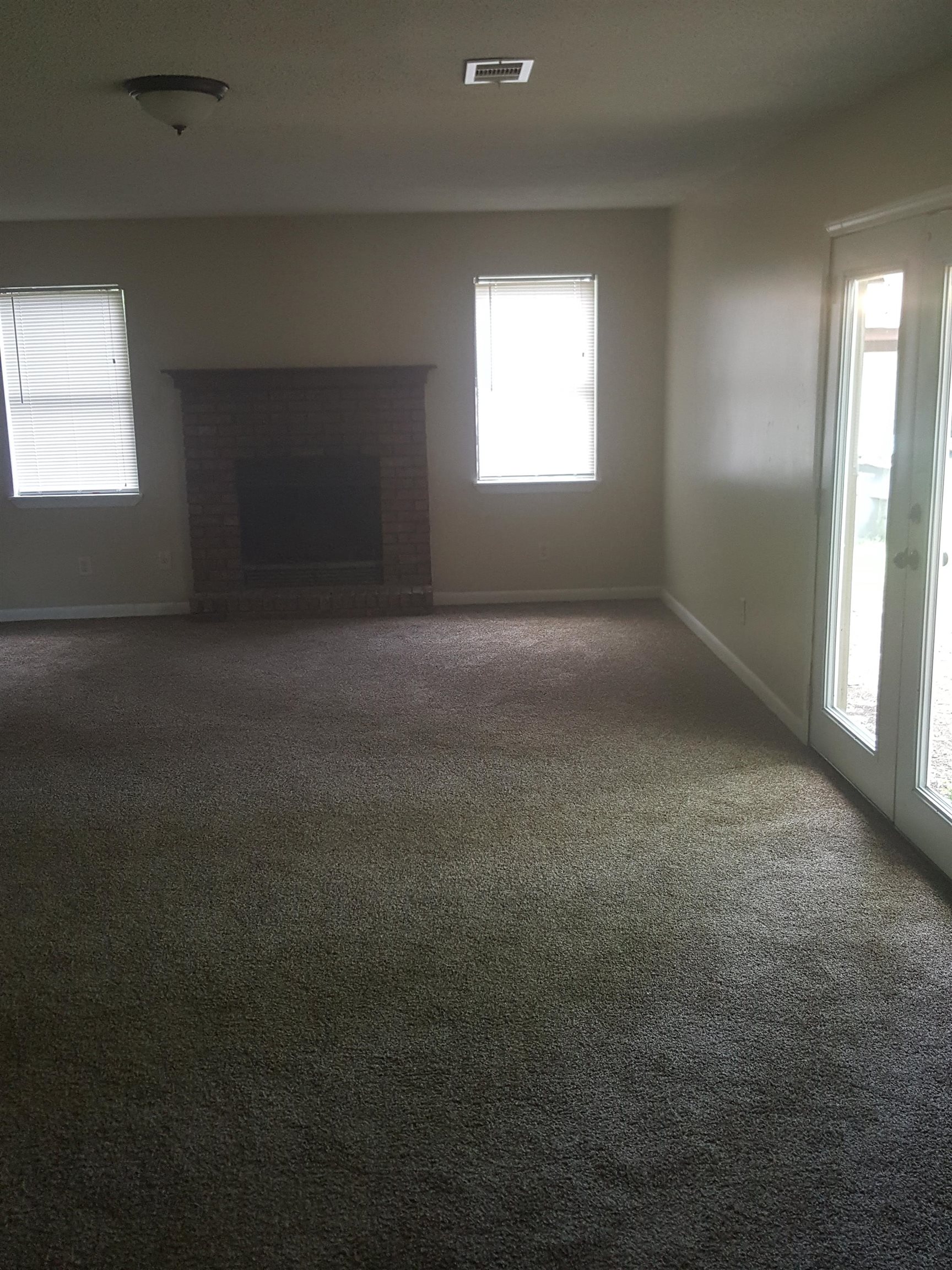 3667 Windermere Road Memphis, TN 38128 - Photo 4 of 8 Unfurnished living room featuring a brick fireplace, carpet, visible vents, and baseboards