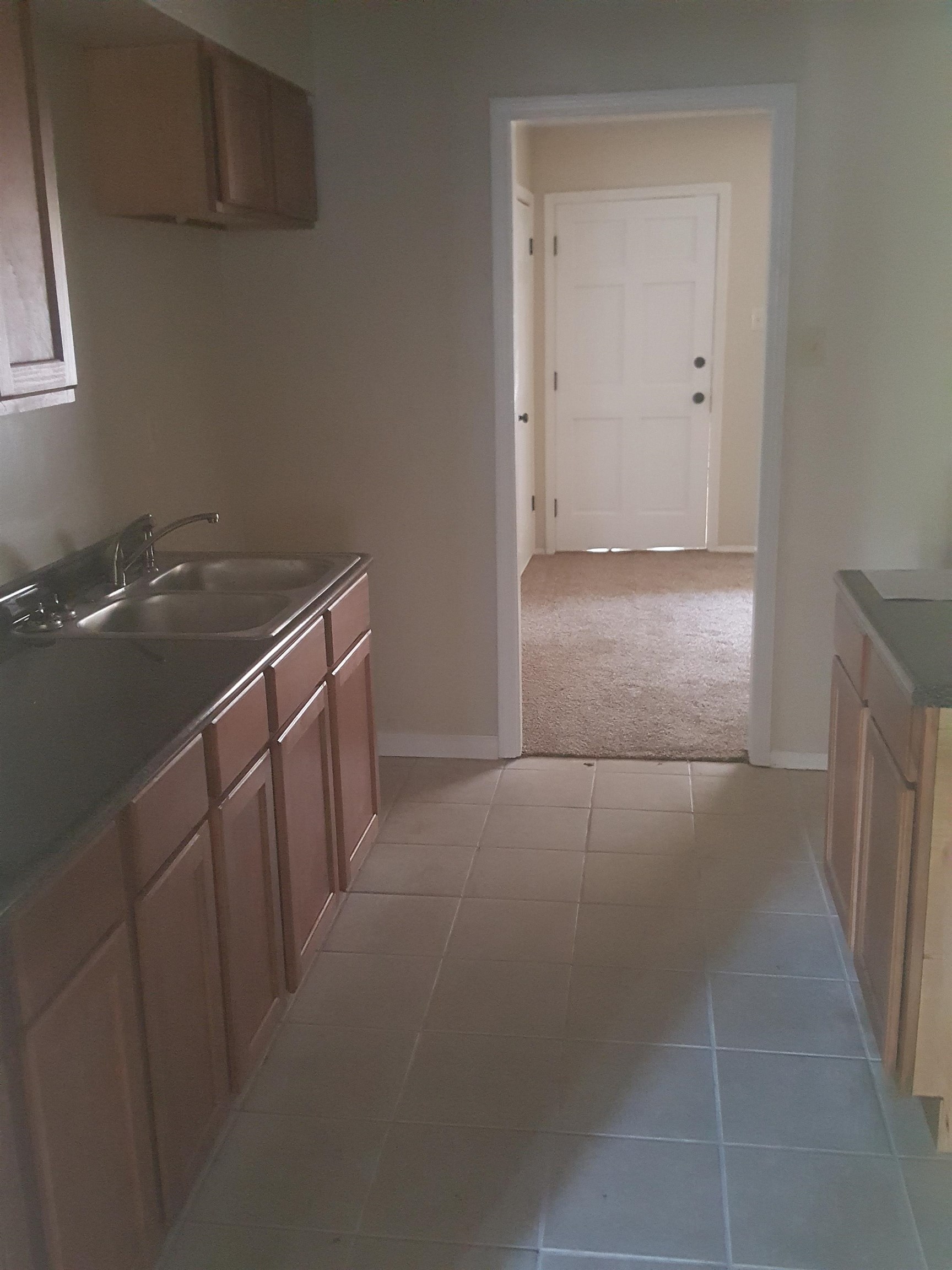 3667 Windermere Road Memphis, TN 38128 - Photo 7 of 8 Kitchen with light tile patterned floors, light colored carpet, baseboards, and a sink