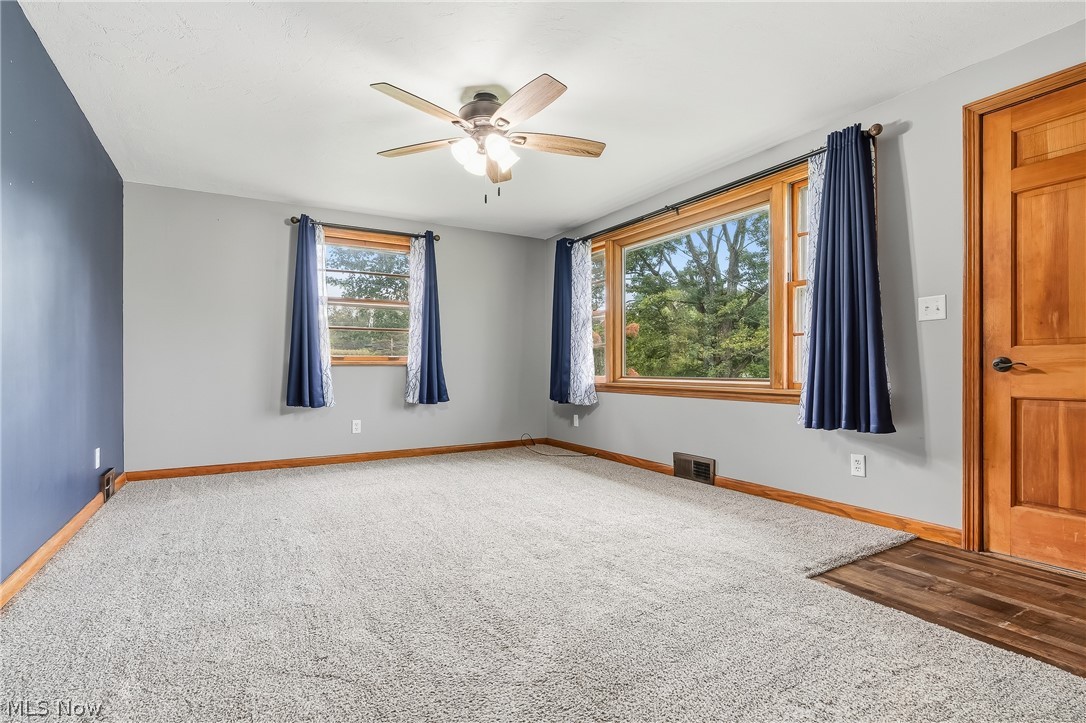 3633 Blacksnake Hill Road Northeast Dover, OH 44622 - Photo 8 of 38 Carpeted flooring, wood-finish trim, multiple windows with wood frames, ceiling fan with integrated lighting, wood-finish door