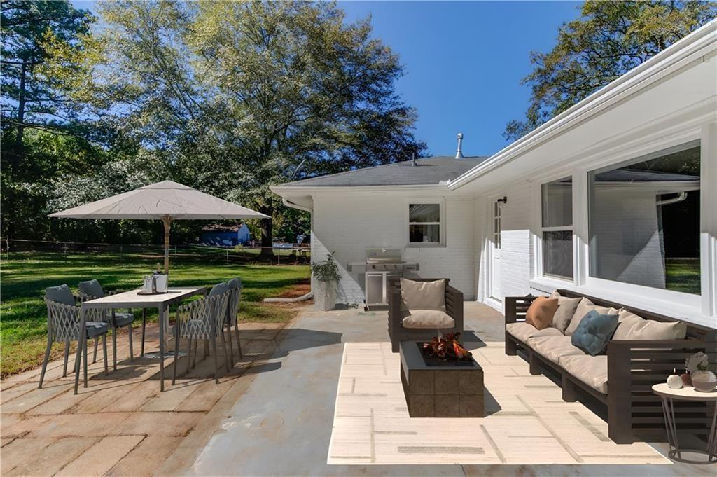 4483 Florence Street Tucker, GA 30084 - Photo 18 of 18 a view of a patio with a table and chairs under an umbrella with a barbeque