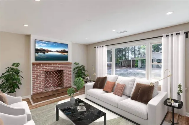a living room with furniture a fireplace and a floor to ceiling window