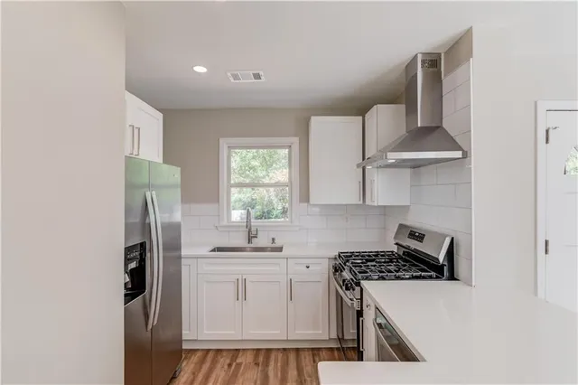a kitchen with stainless steel appliances a refrigerator sink and stove