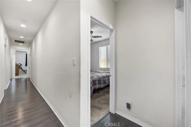 a view of a hallway with wooden floor and staircase