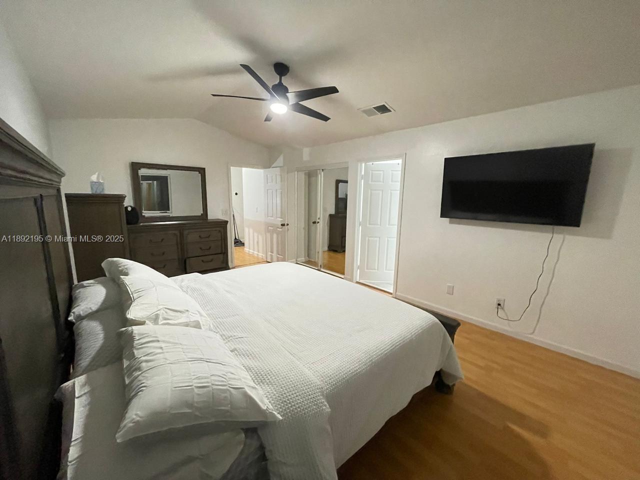 10470 Southwest 16th Street Pembroke Pines, FL 33025 - Photo 12 of 26 a bedroom with a bed and a flat screen tv
