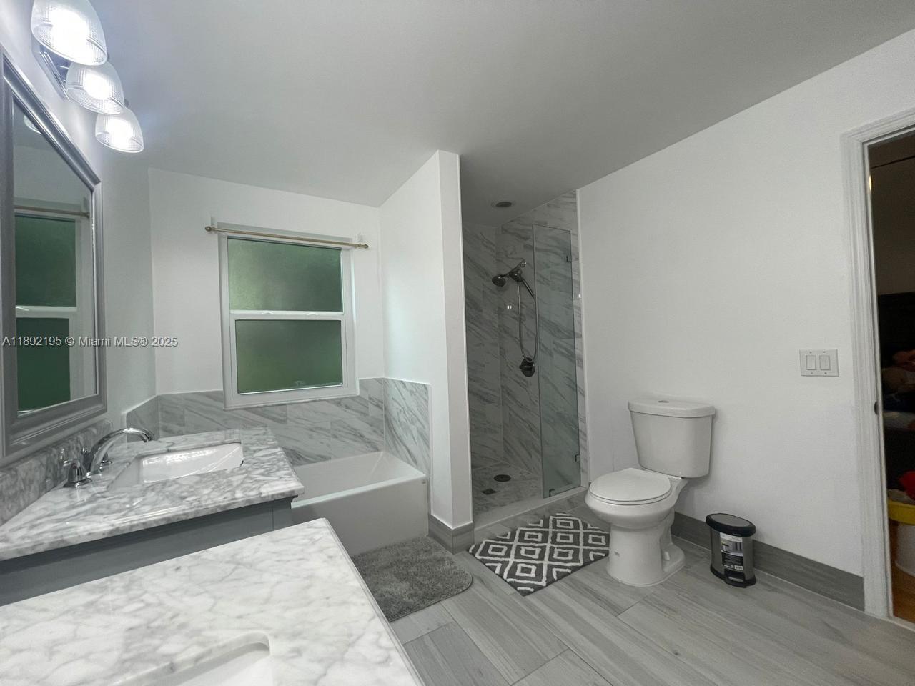 10470 Southwest 16th Street Pembroke Pines, FL 33025 - Photo 13 of 26 a bathroom with a sink toilet and shower