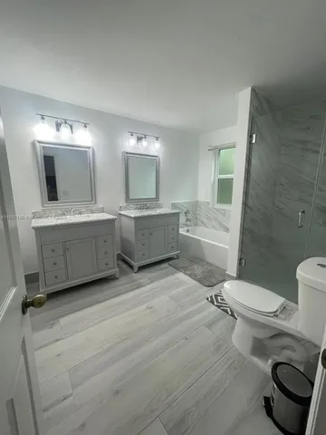 a bathroom with a granite countertop toilet sink and mirror