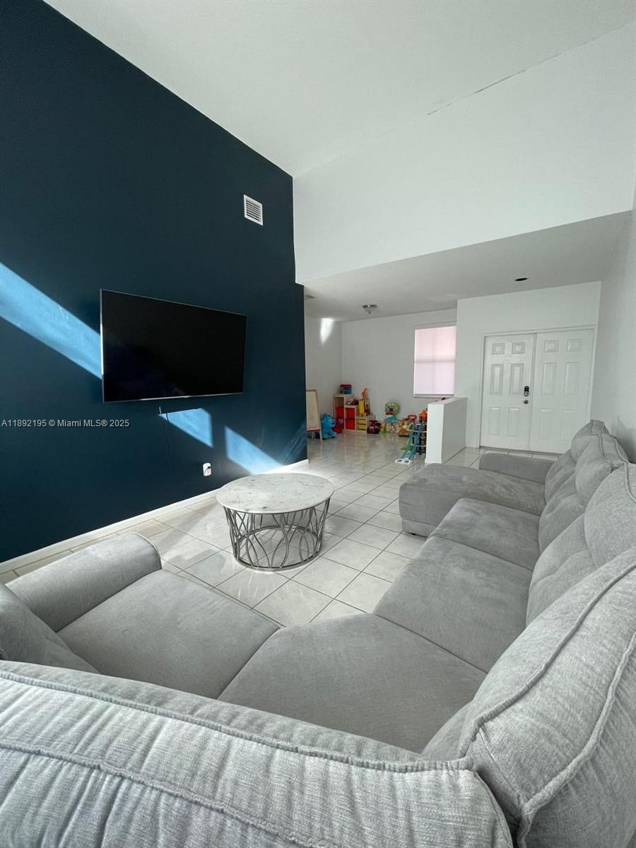 10470 Southwest 16th Street Pembroke Pines, FL 33025 - Photo 4 of 26 a living room with furniture and a flat screen tv