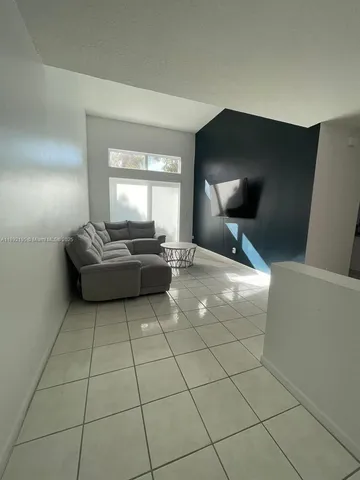 a living room with couches and large mirror with wooden floor