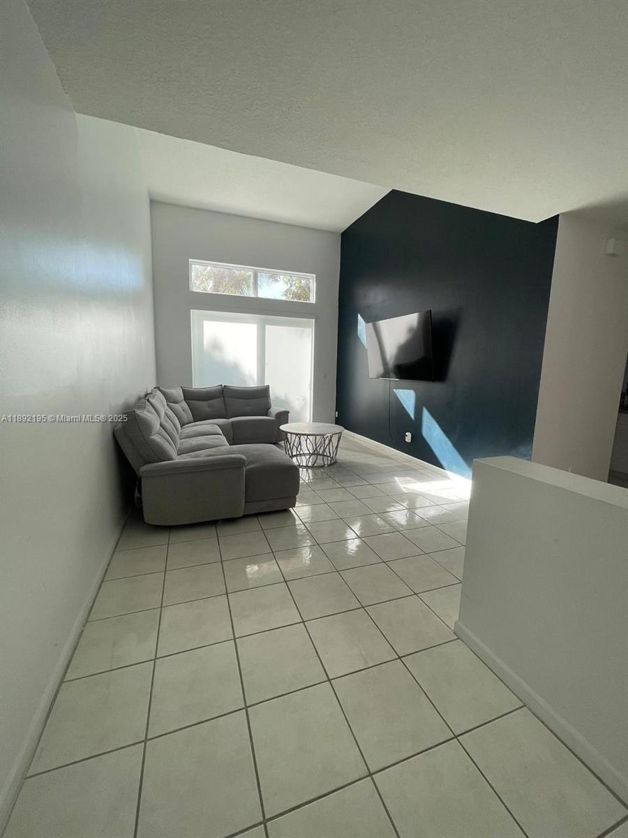 10470 Southwest 16th Street Pembroke Pines, FL 33025 - Photo 5 of 26 a living room with couches and large mirror with wooden floor