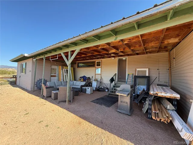 a view of a patio with table and chairs under an umbrella