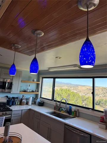 a kitchen with stainless steel appliances granite countertop a sink a stove and a wooden floor