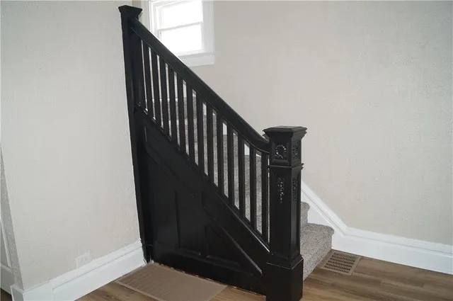 a view of staircase with railing and white walls
