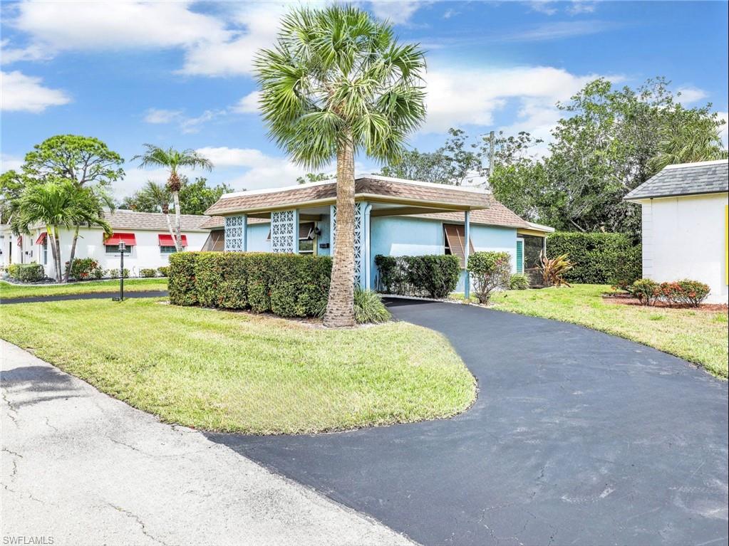 3 Knights Bridge Road, Unit A2 Naples, FL 34112 - Photo 16 of 19 Ranch-style house featuring driveway, stucco siding, a front yard, and a carport