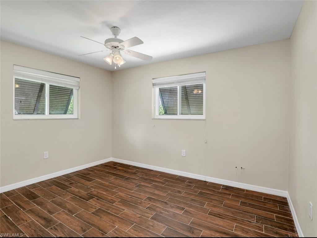 3 Knights Bridge Road, Unit A2 Naples, FL 34112 - Photo 8 of 19 Unfurnished room with baseboards, dark wood-type flooring, and a ceiling fan