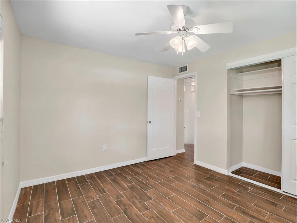 3 Knights Bridge Road, Unit A2 Naples, FL 34112 - Photo 9 of 19 Unfurnished bedroom with wood tiled floor, visible vents, a closet, and baseboards