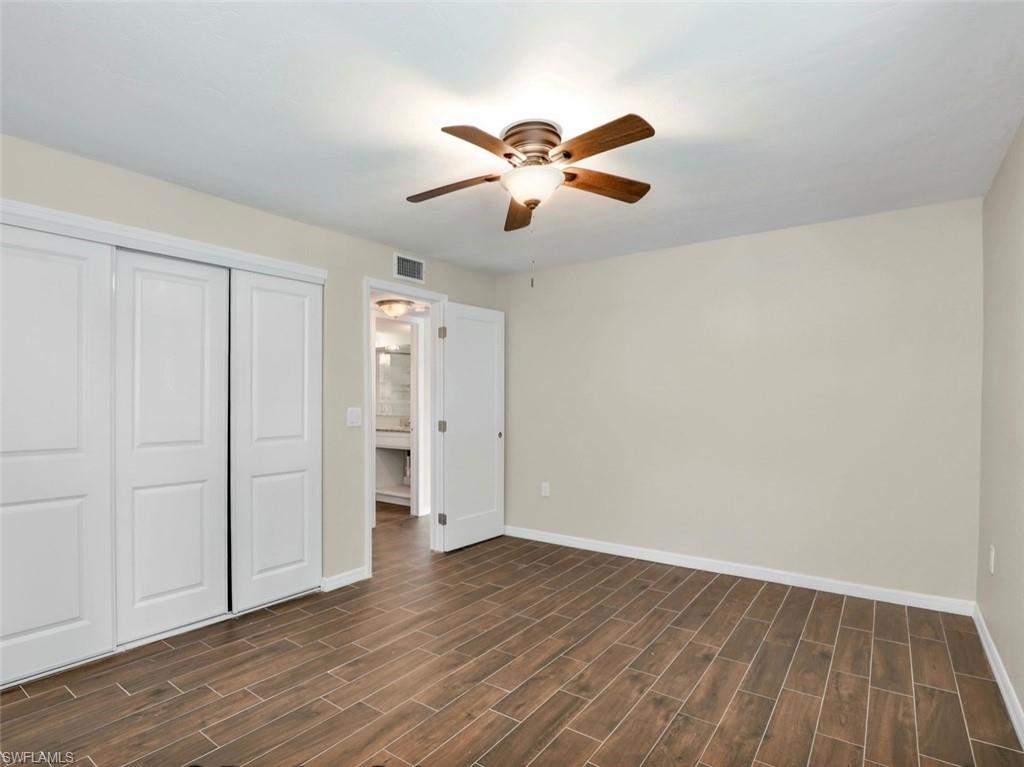 3 Knights Bridge Road, Unit A2 Naples, FL 34112 - Photo 10 of 19 Unfurnished bedroom with baseboards, visible vents, wood finish floors, and a closet