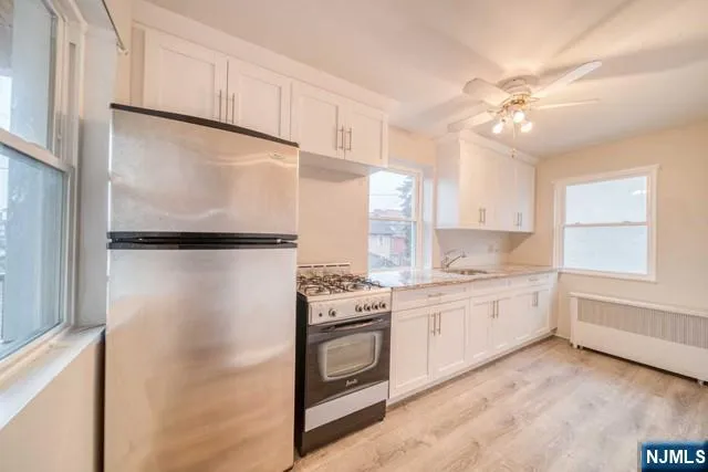 a kitchen with white cabinets and white appliances