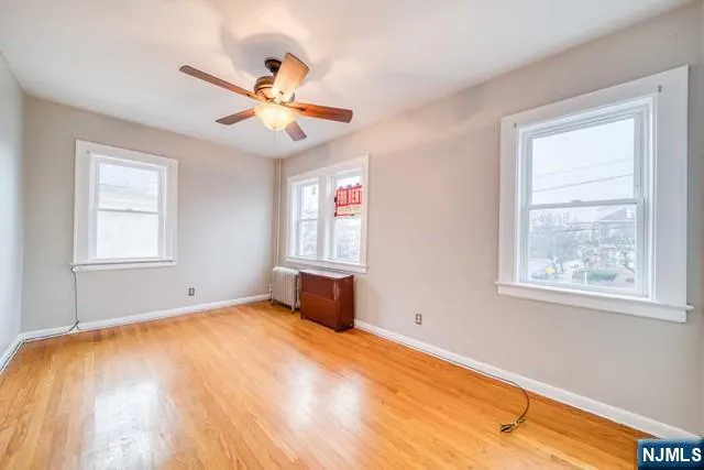 a view of an empty room with chandelier fan and a window