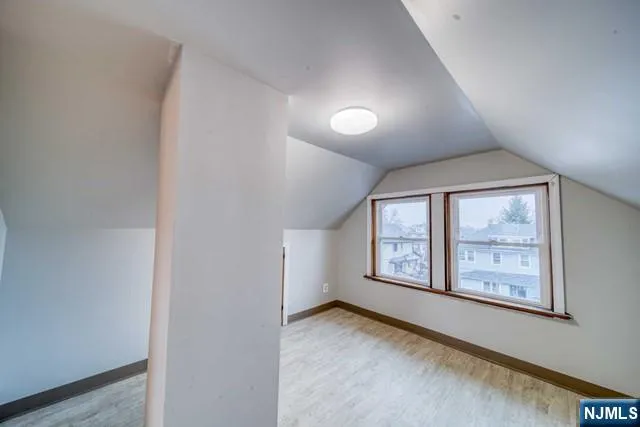 an empty room with windows and ceiling fan