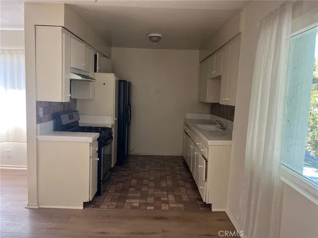 a kitchen with a refrigerator sink stove and cabinets