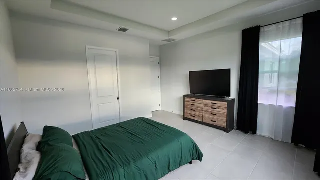 a bedroom with a bed and a flat screen tv