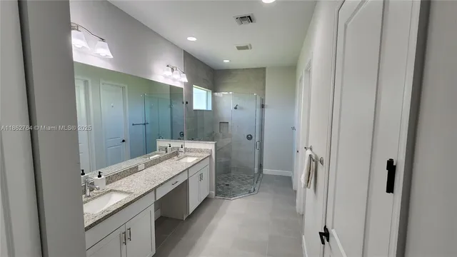 a bathroom with a double vanity sink toilet and shower