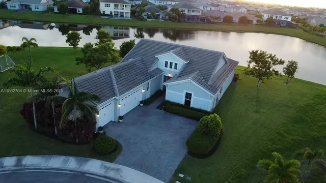 a view of a house with a yard and a pond
