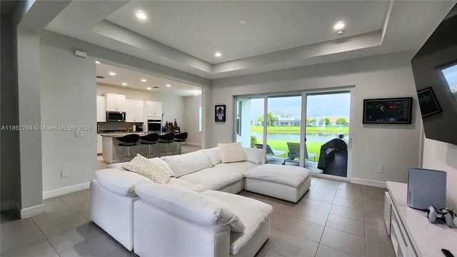 a living room with furniture flat screen tv and a large window
