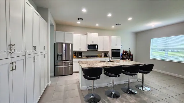 a kitchen with refrigerator and chairs