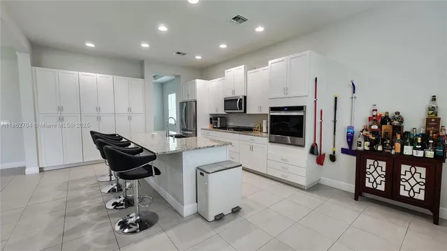 a living room with furniture a fireplace and kitchen view
