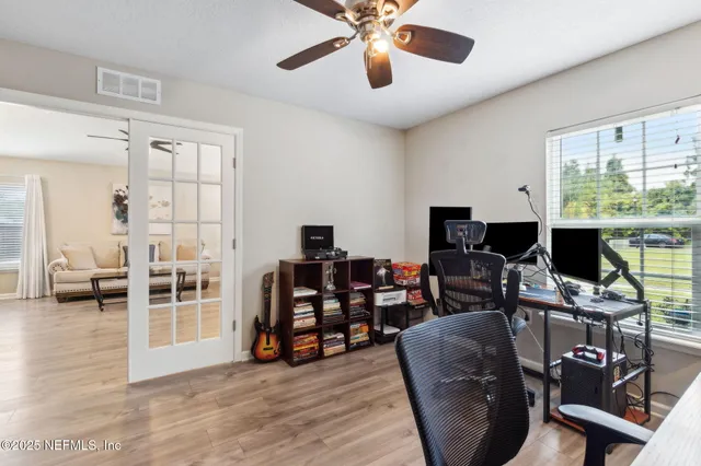 a living room with couches a coffee table and kitchen view with wooden floor