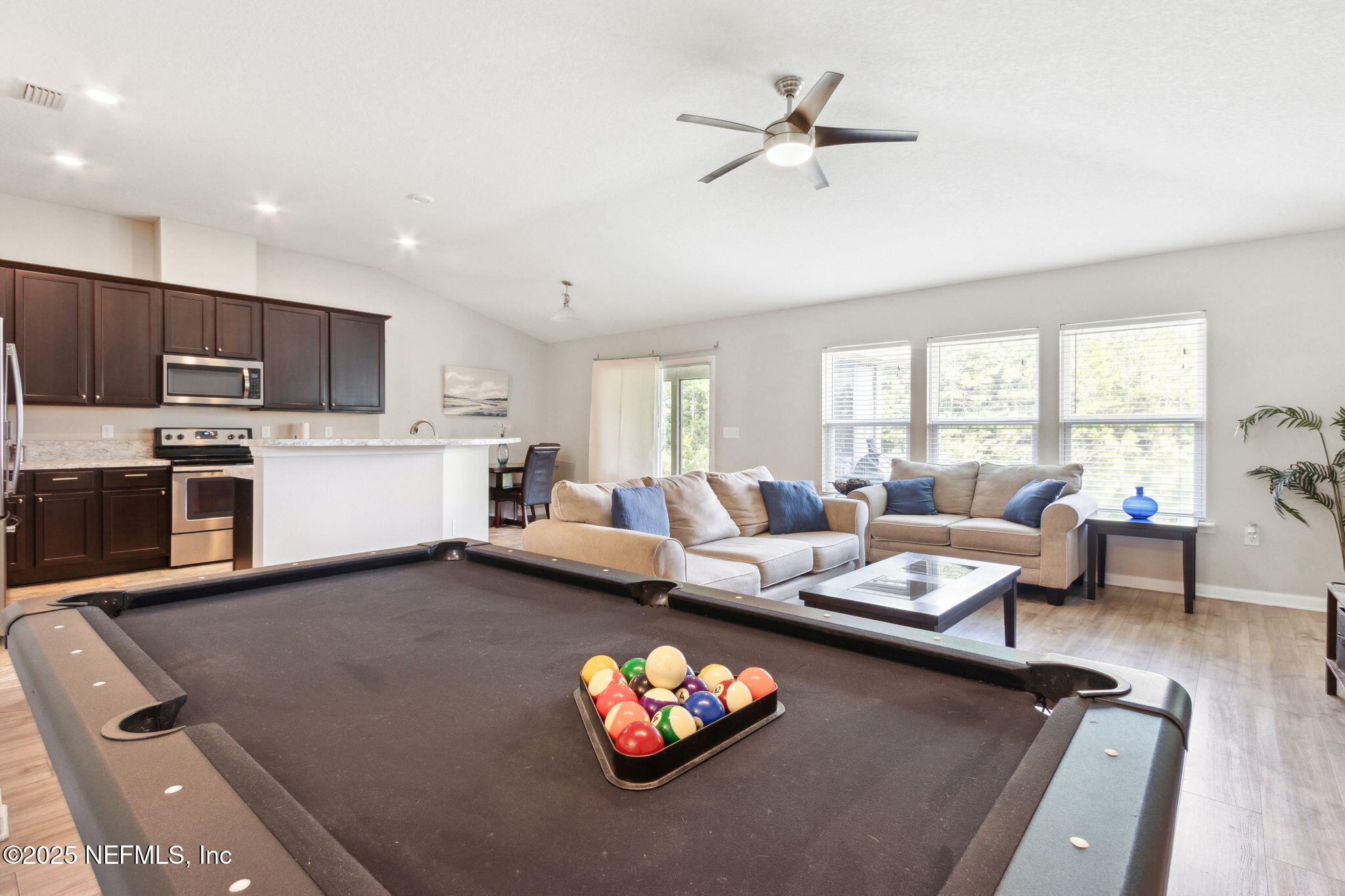 7197 Steventon Way Jacksonville, FL 32244 - Photo 17 of 58 a living room with couches a coffee table and kitchen view with wooden floor