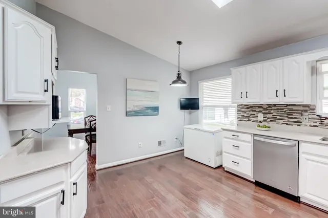a kitchen with white cabinets stainless steel appliances and sink