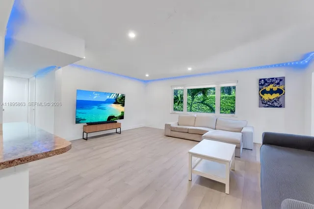 a living room with furniture a flat screen tv and wooden floor