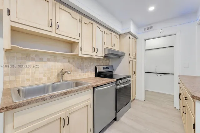 a kitchen with stainless steel appliances granite countertop a sink and a refrigerator