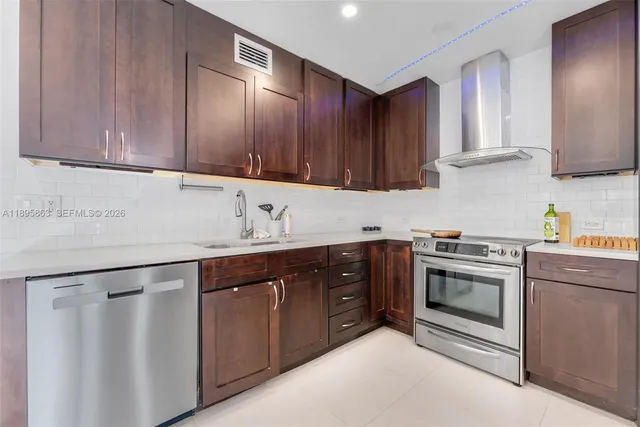 a kitchen with stainless steel appliances granite countertop a sink stove and cabinets