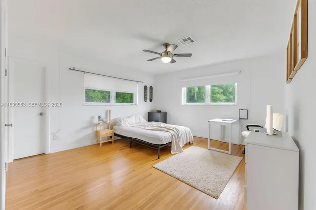 a bedroom with a bed and wooden floor