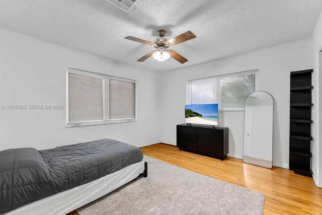 a bedroom with a bed and a ceiling fan