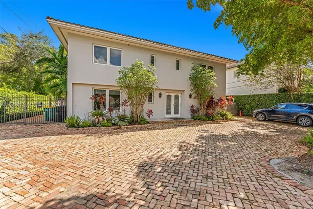 a front view of a house with a yard and potted plants