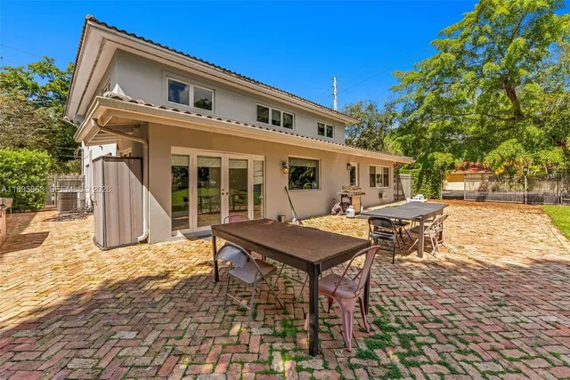 a backyard of a house with table and chairs