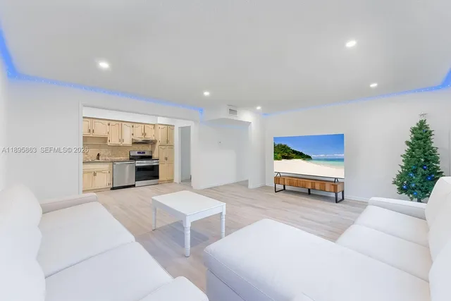 a living room with furniture and a kitchen view