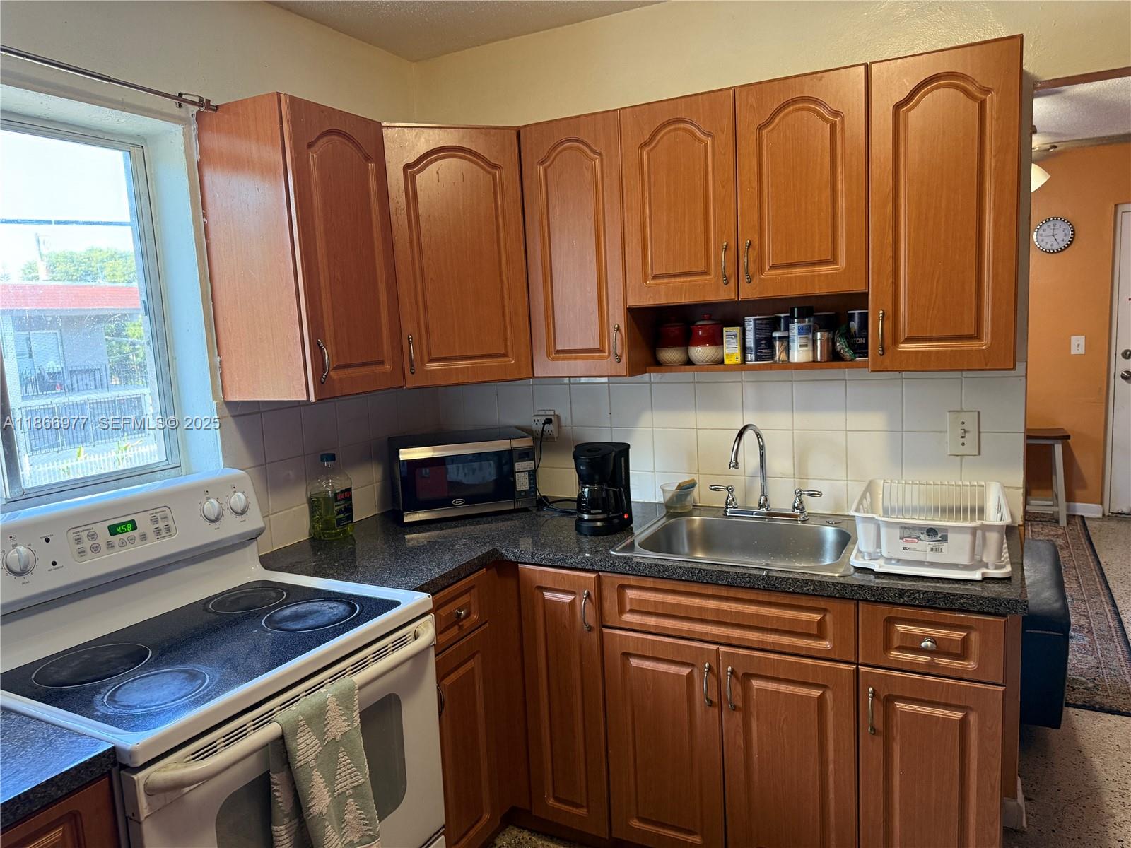 502 Southwest 13th Avenue Miami, FL 33135 - Photo 45 of 48 a kitchen with granite countertop a sink a stove and cabinets