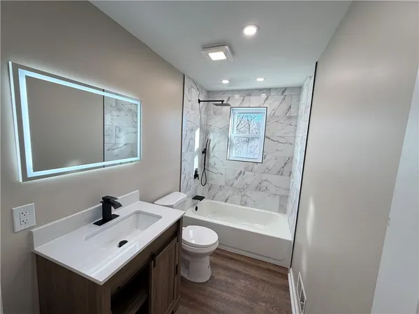 a bathroom with a sink a toilet and shower