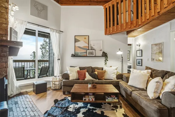 a living room with furniture wooden floor and a table
