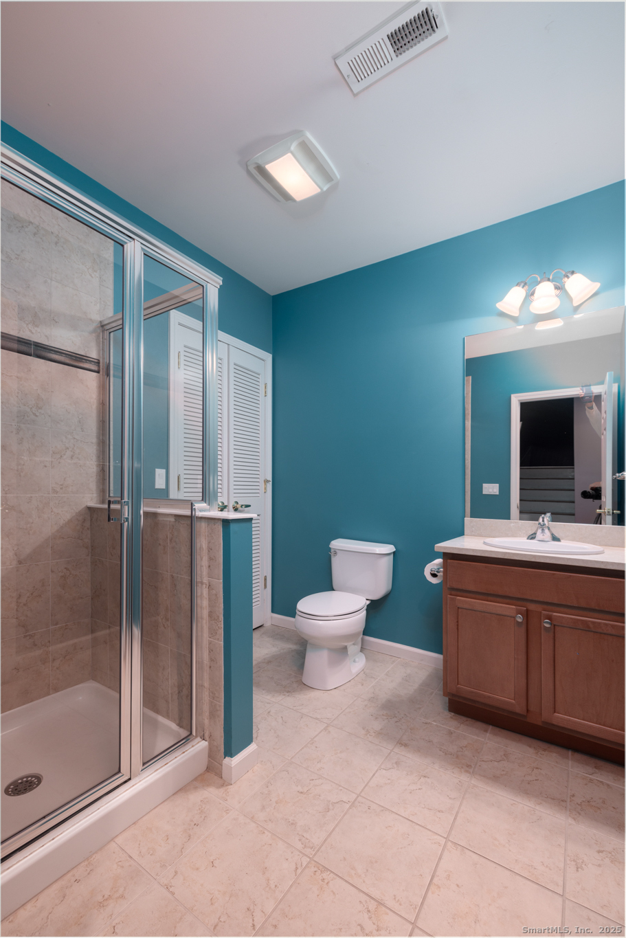 49 Park Pl Circle, Unit 49 West Hartford, CT 06110 - Photo 25 of 33 a spacious bathroom with a toilet a sink and mirror