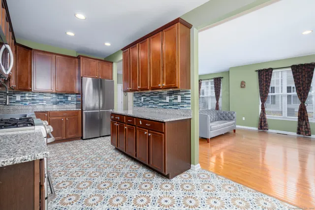 a kitchen with stainless steel appliances granite countertop a stove refrigerator and cabinets