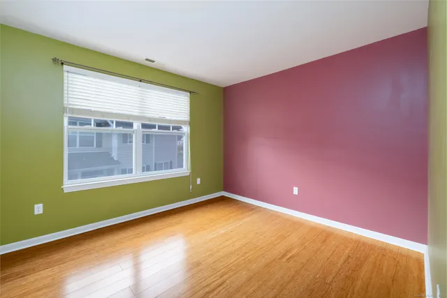 an empty room with a window and a ceiling fan